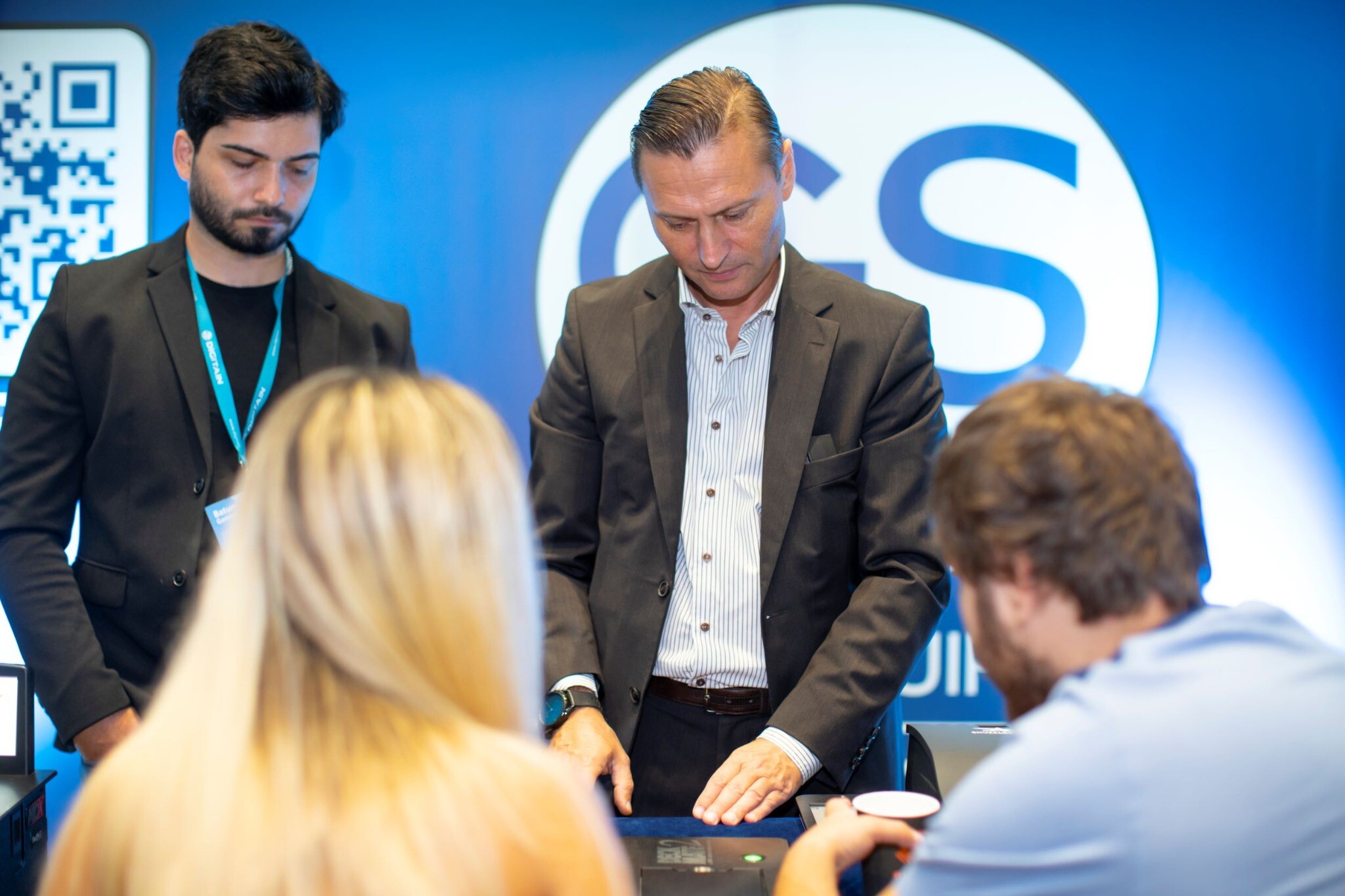 Gaming Supplies representatives demonstrating casino equipment to industry visitors at the GS exhibition stand
